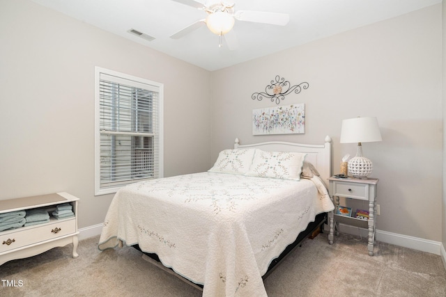 carpeted bedroom with visible vents, baseboards, and a ceiling fan