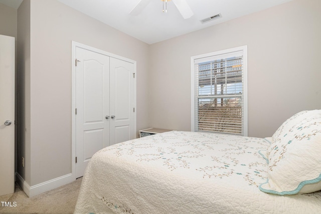 bedroom with visible vents, light carpet, a ceiling fan, a closet, and baseboards