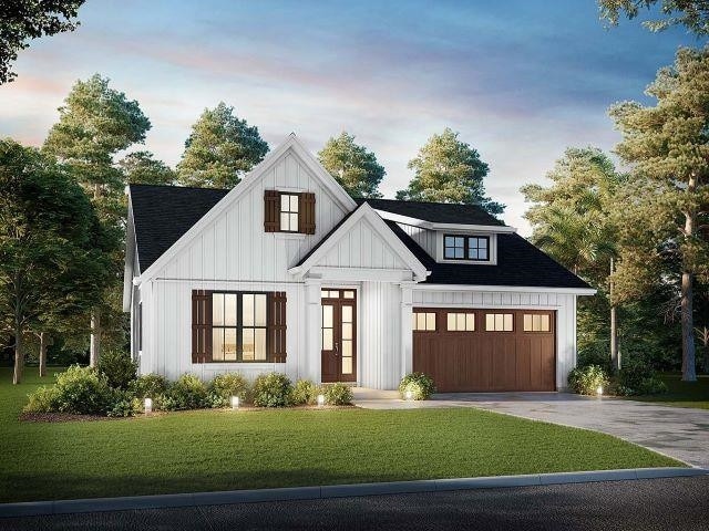 modern inspired farmhouse with a yard, a shingled roof, concrete driveway, board and batten siding, and a garage