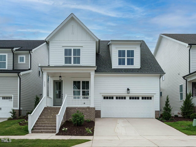 view of front of house featuring a porch, an attached garage, concrete driveway, roof with shingles, and board and batten siding