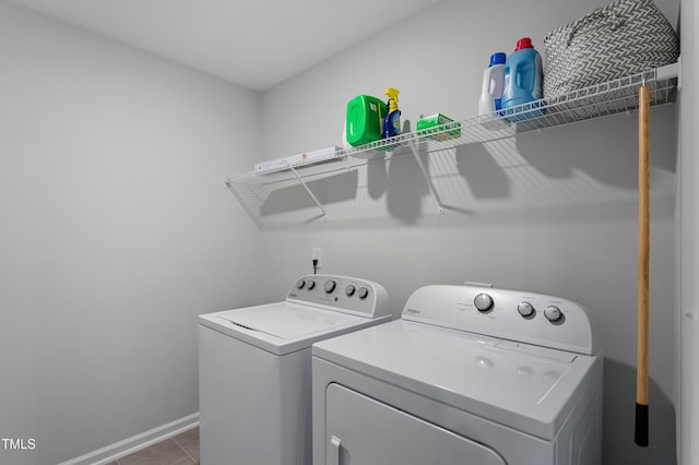 washroom featuring laundry area, washing machine and dryer, baseboards, and tile patterned floors