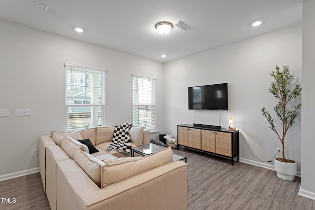 living area with recessed lighting, baseboards, and wood finished floors