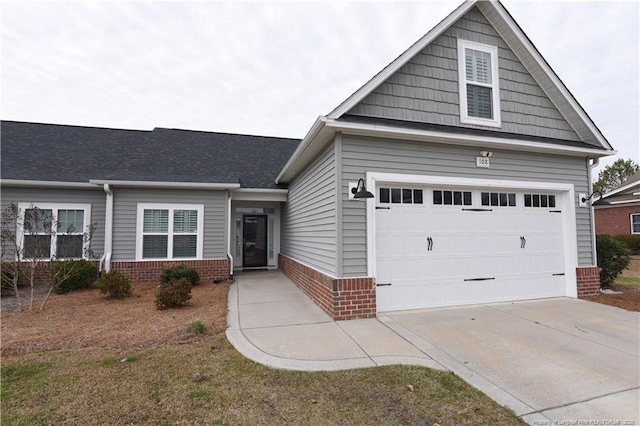 view of front of house featuring a garage, concrete driveway, and brick siding