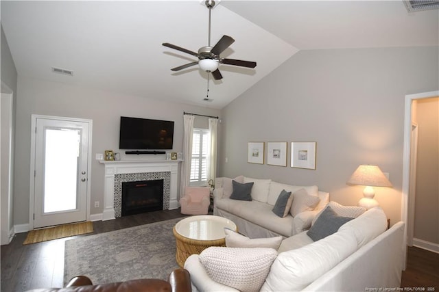 living room featuring lofted ceiling, dark wood-style flooring, and visible vents