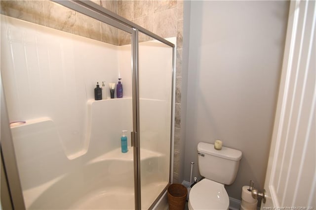 full bathroom with a stall shower and toilet