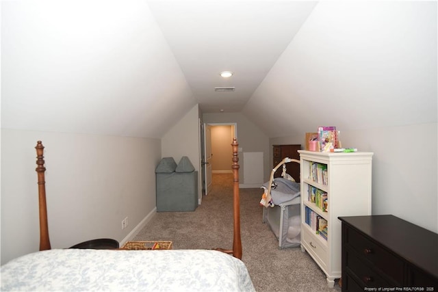 bedroom featuring baseboards, visible vents, vaulted ceiling, and light colored carpet