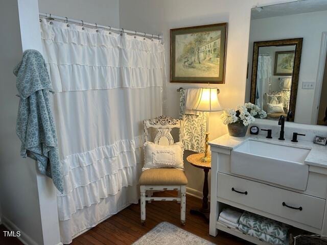 bathroom with curtained shower, wood finished floors, and vanity