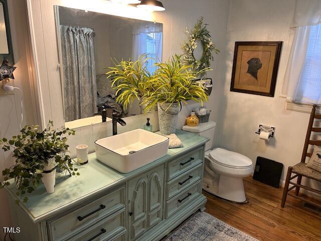 bathroom with vanity, toilet, and wood finished floors