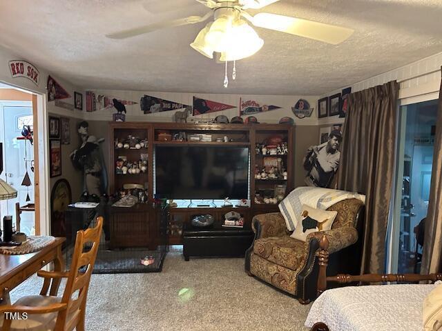 living area featuring ceiling fan, speckled floor, and a textured ceiling