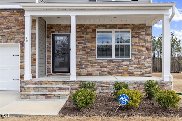 property entrance with a porch, stone siding, and an attached garage