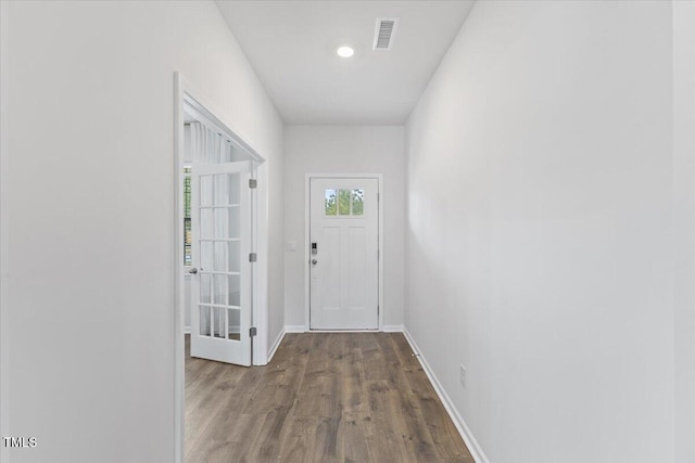 entryway with baseboards, visible vents, and wood finished floors