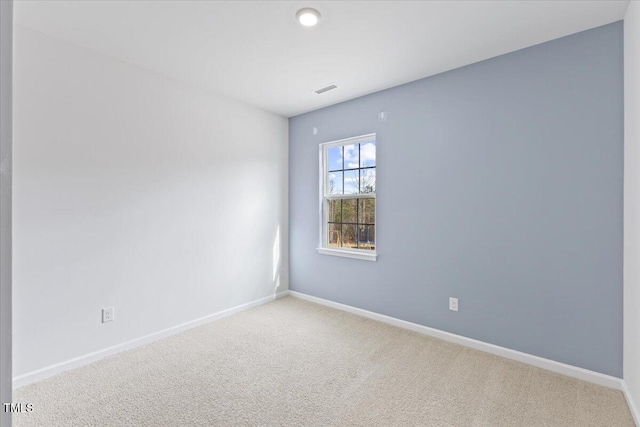 carpeted empty room featuring visible vents and baseboards