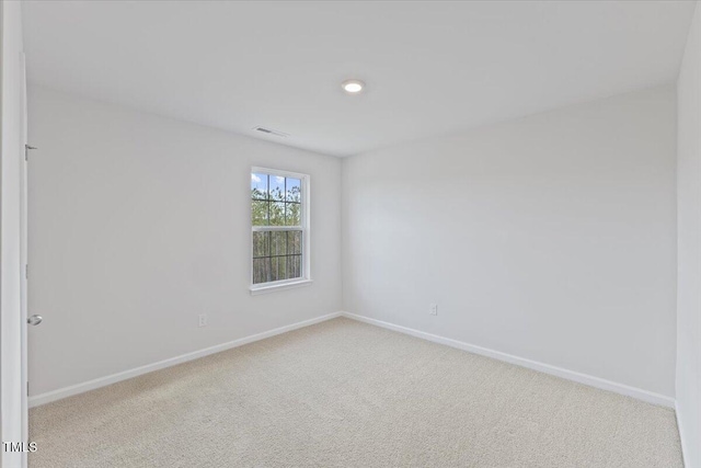 carpeted empty room featuring baseboards and visible vents