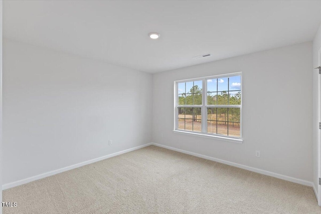 carpeted empty room featuring baseboards