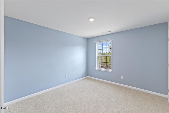 carpeted empty room with visible vents and baseboards