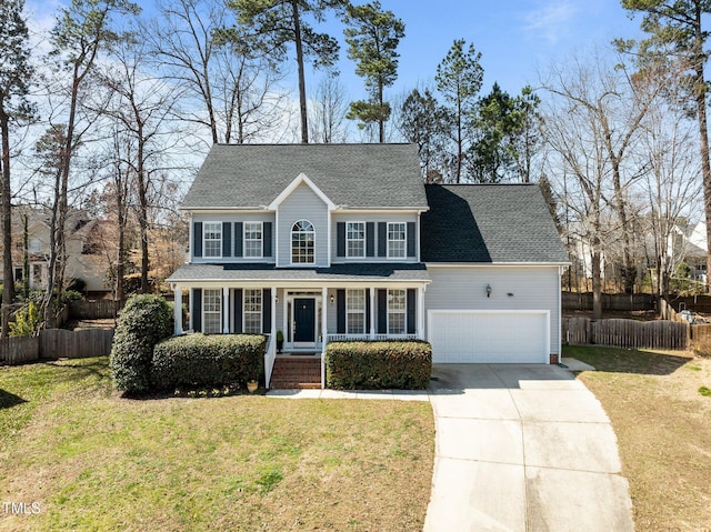 colonial-style house featuring a shingled roof, fence, concrete driveway, a front yard, and an attached garage