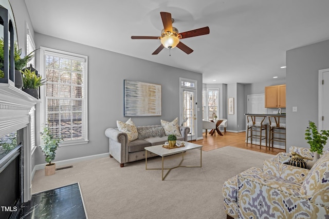 living area featuring recessed lighting, a fireplace, baseboards, and a ceiling fan