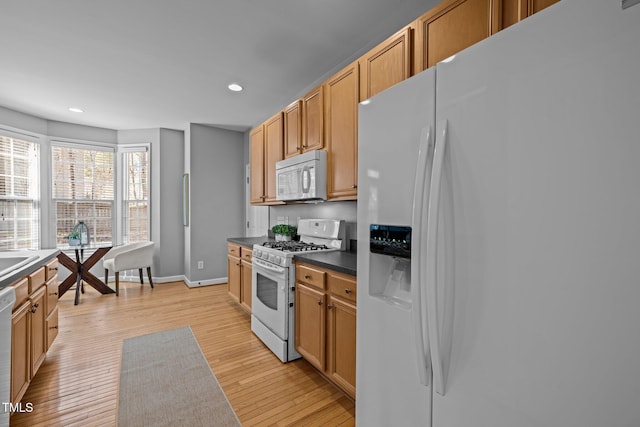 kitchen featuring white appliances, recessed lighting, dark countertops, and light wood-style floors