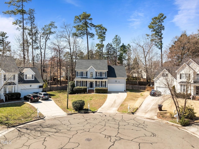 view of front facade with concrete driveway, a garage, fence, and a front lawn