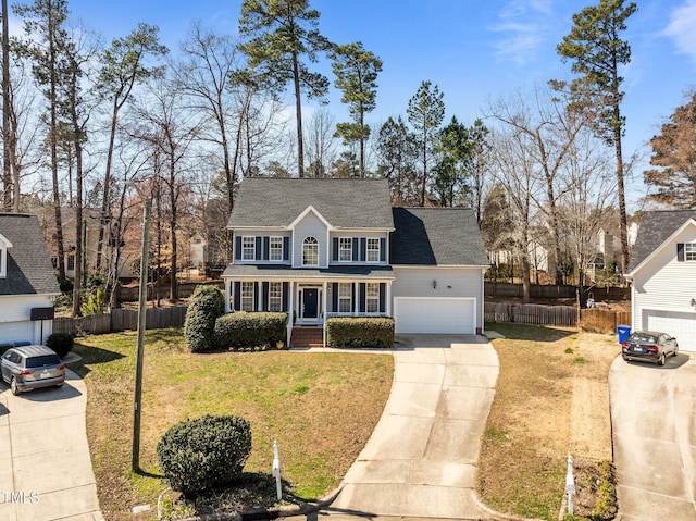 view of front of home with a front yard, fence, driveway, a shingled roof, and a garage