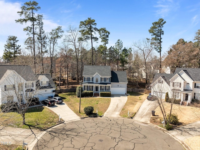 view of front of house featuring a garage, concrete driveway, a front lawn, and fence