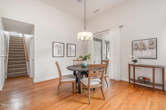 dining space with stairway, baseboards, and light wood-style floors