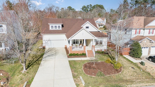 view of front of home featuring brick siding, concrete driveway, a front yard, covered porch, and a garage