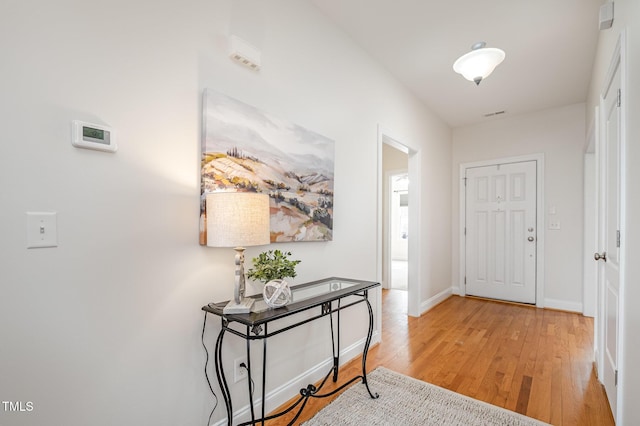 foyer with light wood finished floors and baseboards