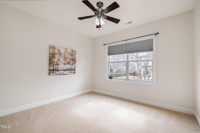 empty room with visible vents, carpet flooring, baseboards, and ceiling fan