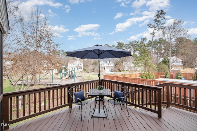 wooden terrace with a playground and fence