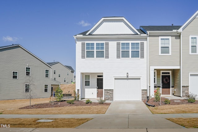 multi unit property with a garage, stone siding, and concrete driveway