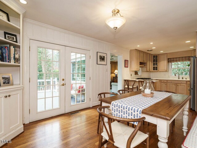 dining room featuring visible vents, light wood finished floors, recessed lighting, french doors, and crown molding