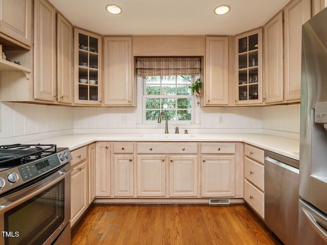 kitchen featuring a sink, visible vents, appliances with stainless steel finishes, and light brown cabinetry