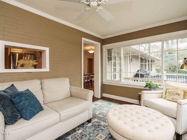 living room featuring a healthy amount of sunlight, brick wall, and crown molding