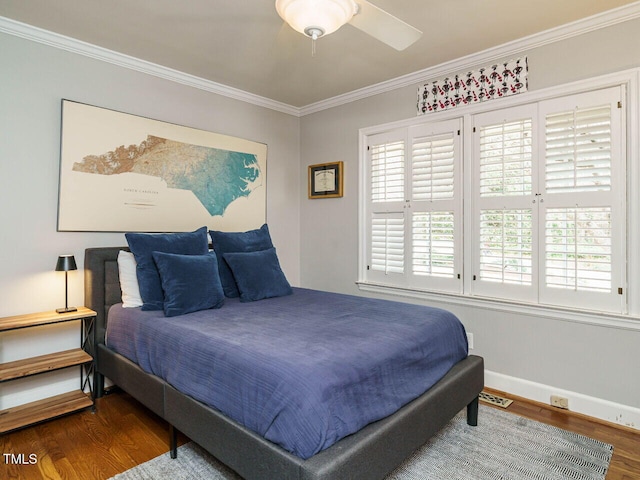 bedroom with visible vents, ornamental molding, baseboards, and wood finished floors