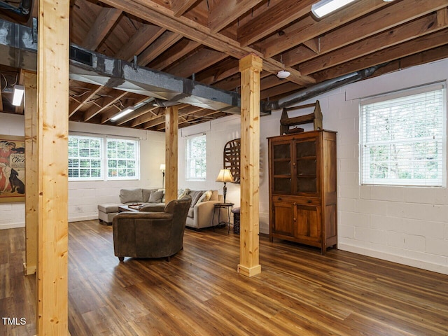 living room with concrete block wall, ornate columns, and wood finished floors