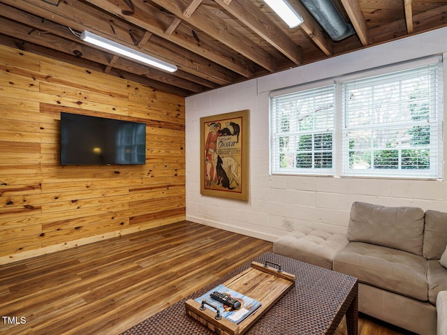 living area with dark wood-style floors and concrete block wall