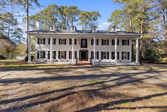 neoclassical home with stucco siding and a porch