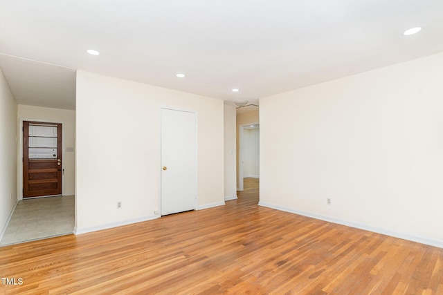 spare room featuring recessed lighting, baseboards, and light wood-style flooring