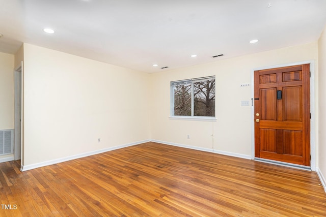 empty room featuring recessed lighting, visible vents, baseboards, and wood finished floors