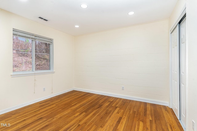 spare room featuring recessed lighting, visible vents, baseboards, and wood finished floors