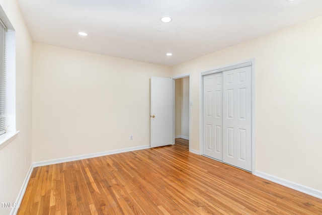 unfurnished bedroom featuring recessed lighting, a closet, baseboards, and light wood-style flooring