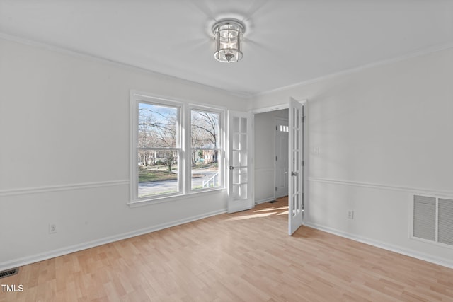 unfurnished room with visible vents, crown molding, and wood finished floors