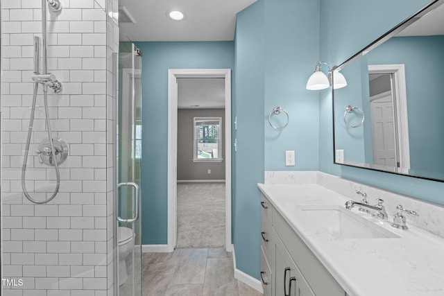 full bath featuring baseboards, vanity, and a shower stall