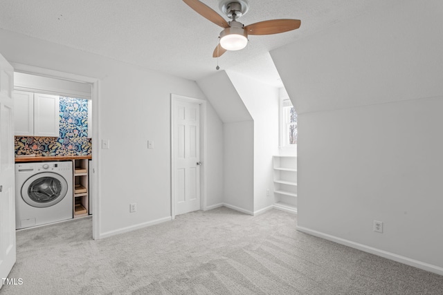 additional living space featuring carpet flooring, washer / clothes dryer, baseboards, and a textured ceiling