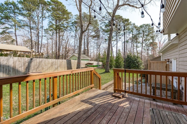 wooden terrace with a yard and fence