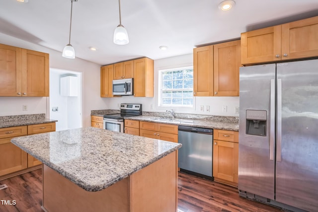 kitchen with a sink, appliances with stainless steel finishes, dark wood finished floors, and light stone countertops