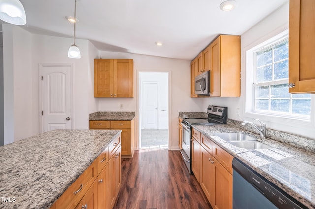 kitchen with light stone counters, decorative light fixtures, dark wood finished floors, appliances with stainless steel finishes, and a sink