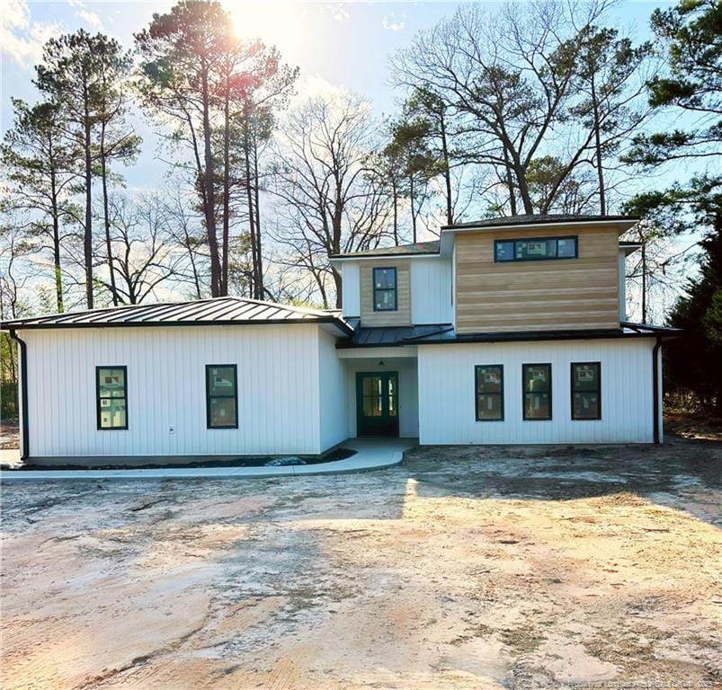 view of front of house with metal roof, a standing seam roof, and driveway