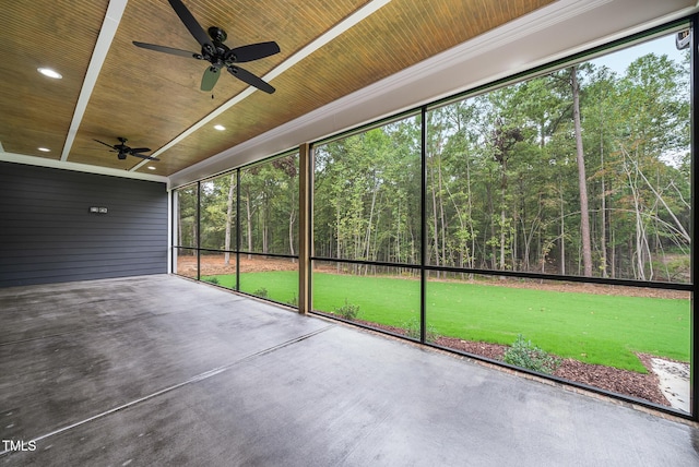 unfurnished sunroom with a forest view and wooden ceiling